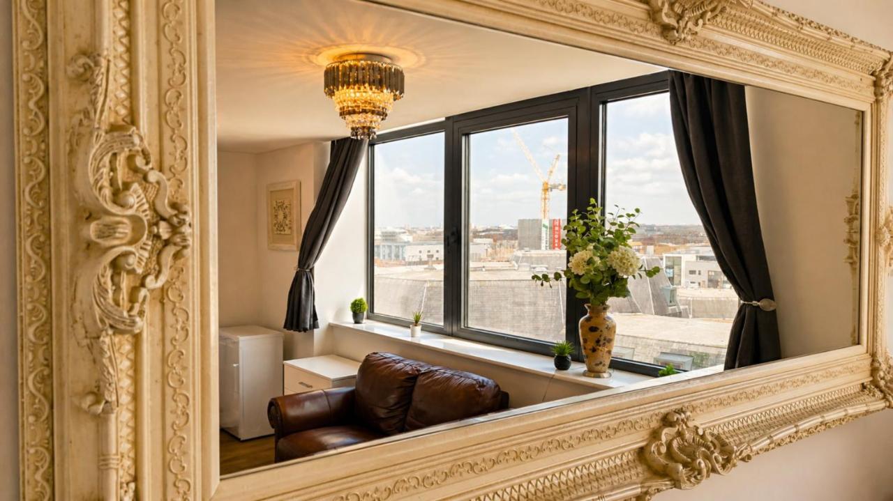 Ornate mirror reflecting the living room and skyline windows at the Tithebarn Street apartment
