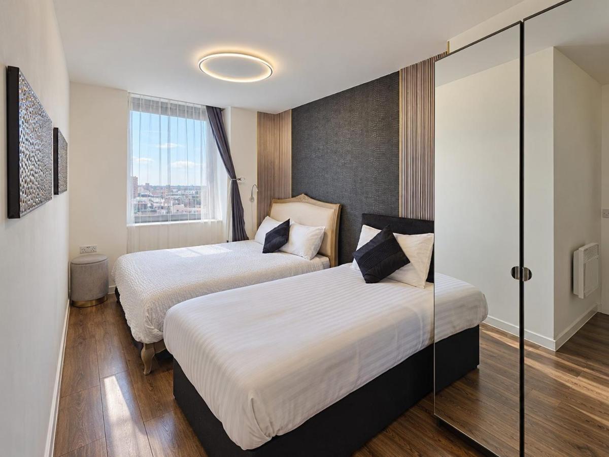 two beds in a hotel room with a window at Sidemersey Livings - 2 Bedroom Central Skyline Apartment with views and parking in Liverpool