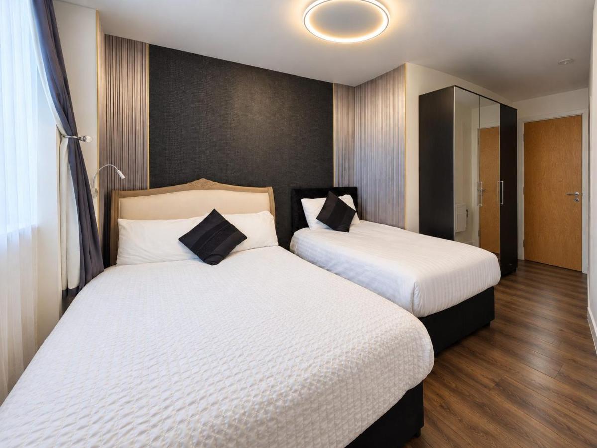 two beds in a hotel room with two at Sidemersey Livings - 2 Bedroom Central Skyline Apartment with views and parking in Liverpool